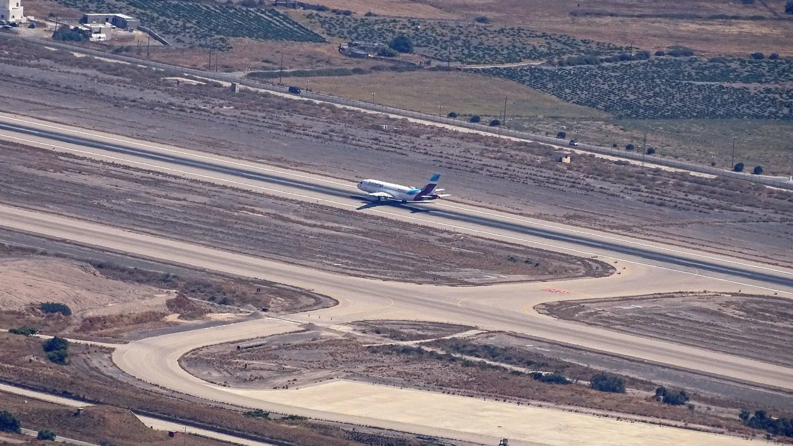 An aircraft landing on the runway of Santorini Airport, seen from Profitis Ilias