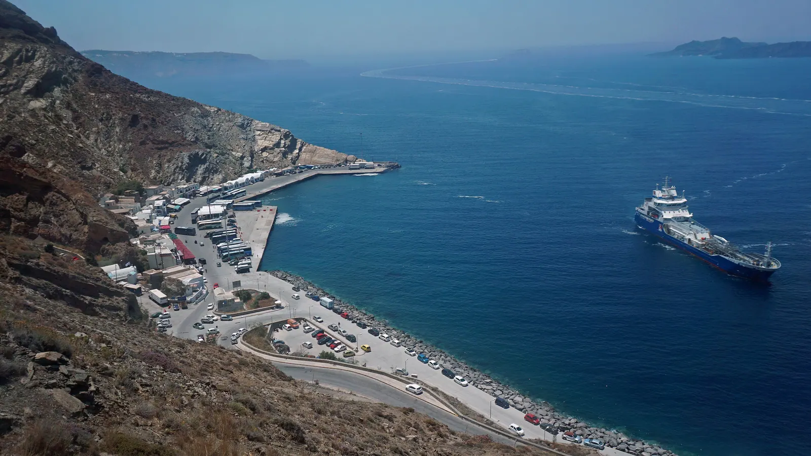 Athinios port from the road above: the ferry pier, the switchbacks and a ferry arriving