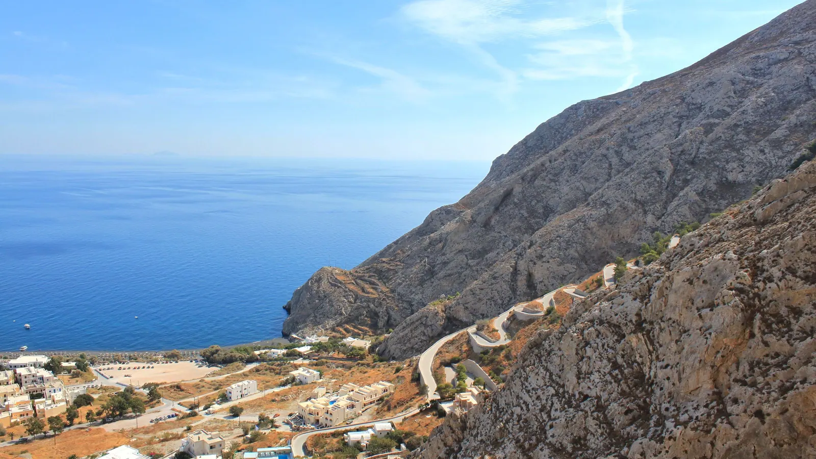 The coast road above Kamari rounding Mesa Vouno, the beach and the sea below