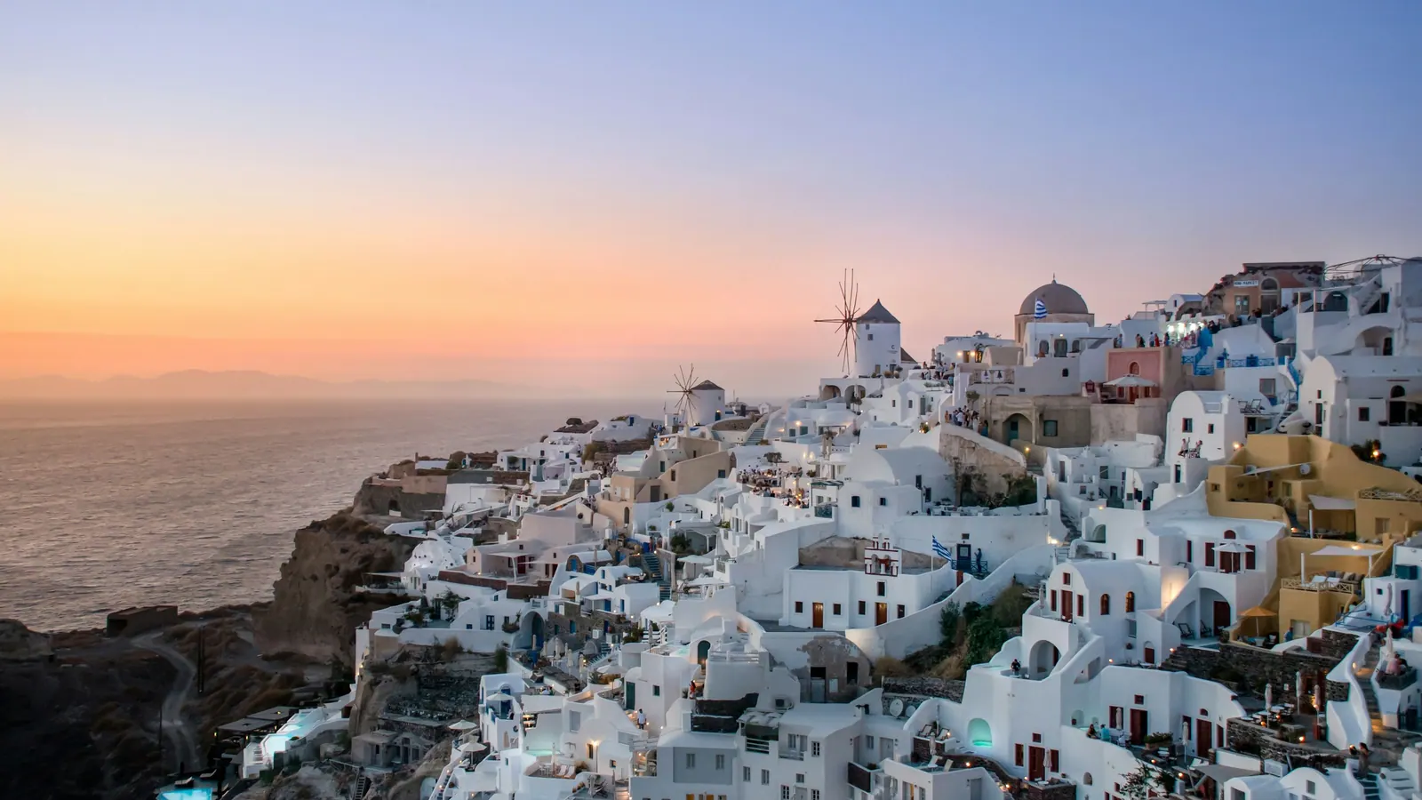 Oia at sunset, the windmill and the houses on the caldera edge